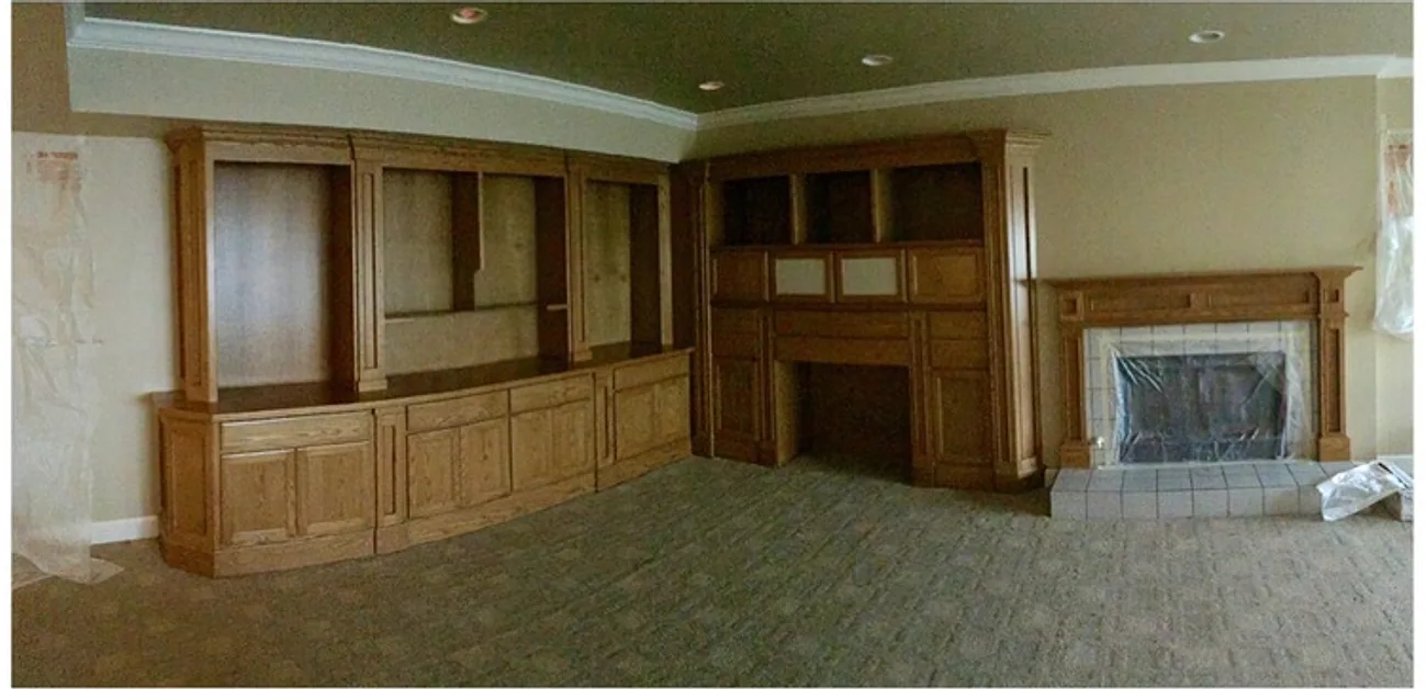 Living room with dark stained built-in cabinetry and mantel, before painting