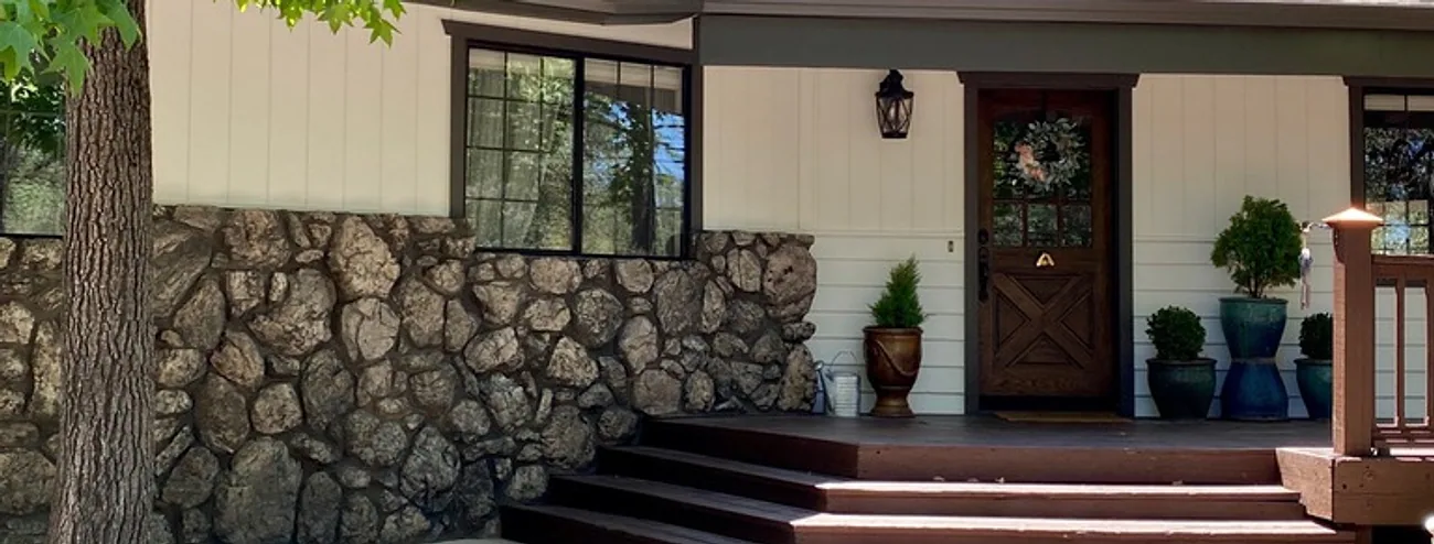 The same home exterior after Talbot Painting repainted it in warm cream with dark brown trim