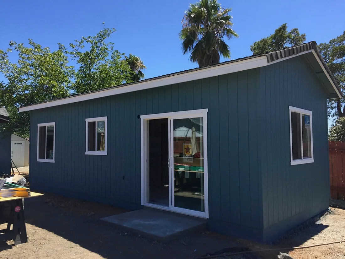 Building exterior painted in deep blue with white window trim