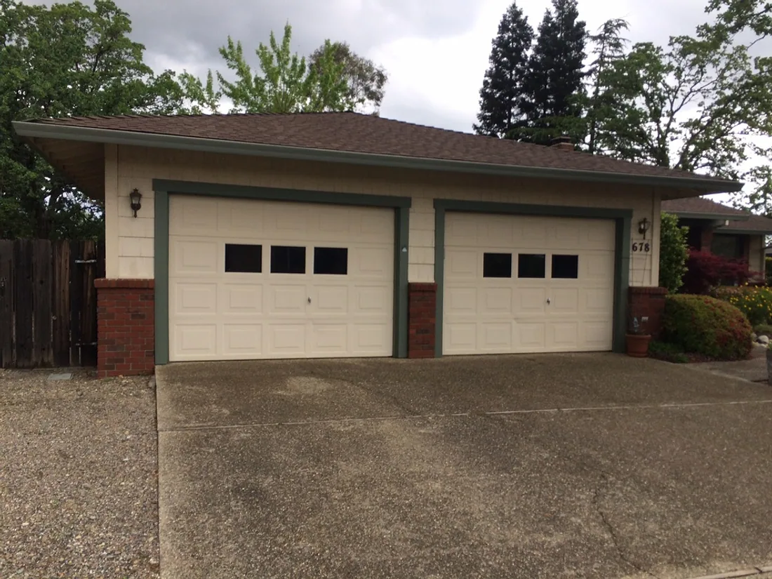 Home exterior with painted garage doors, trim and brick accents